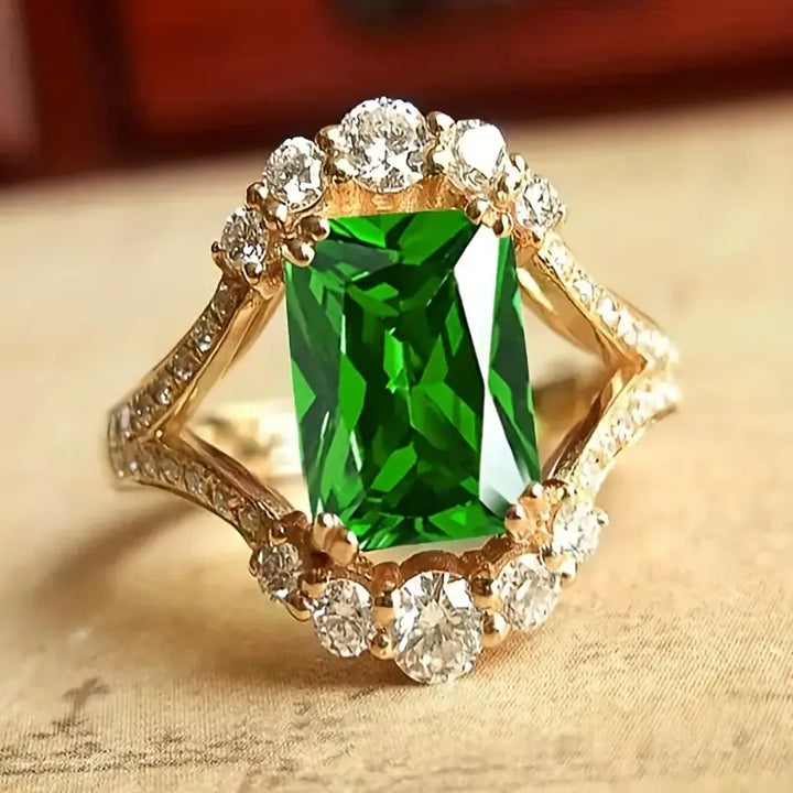Anillo verde esmeralda con halo de brillos · Dorado