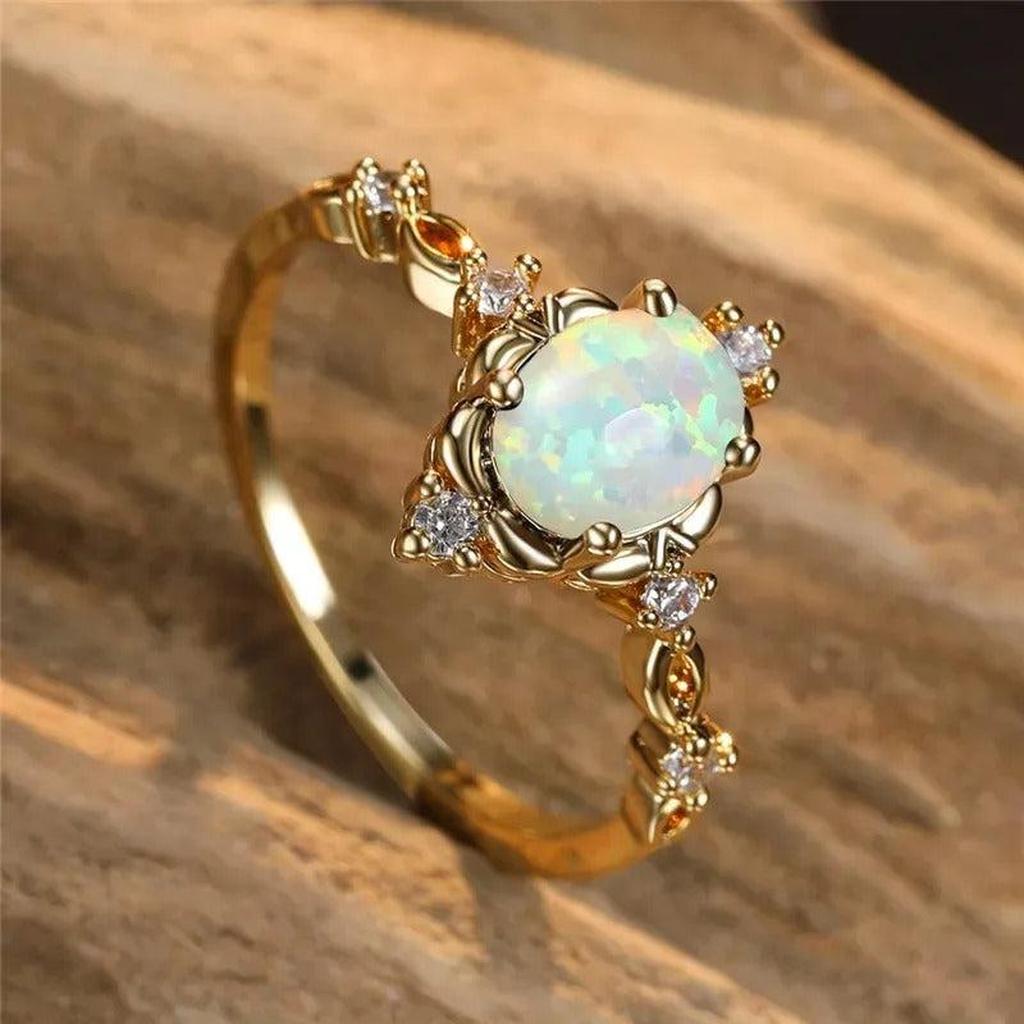 Anillo con piedra efecto ópalo y brillos · Dorado