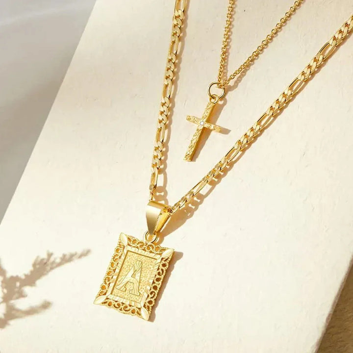 Collar doble con cruz e inicial · Dorado