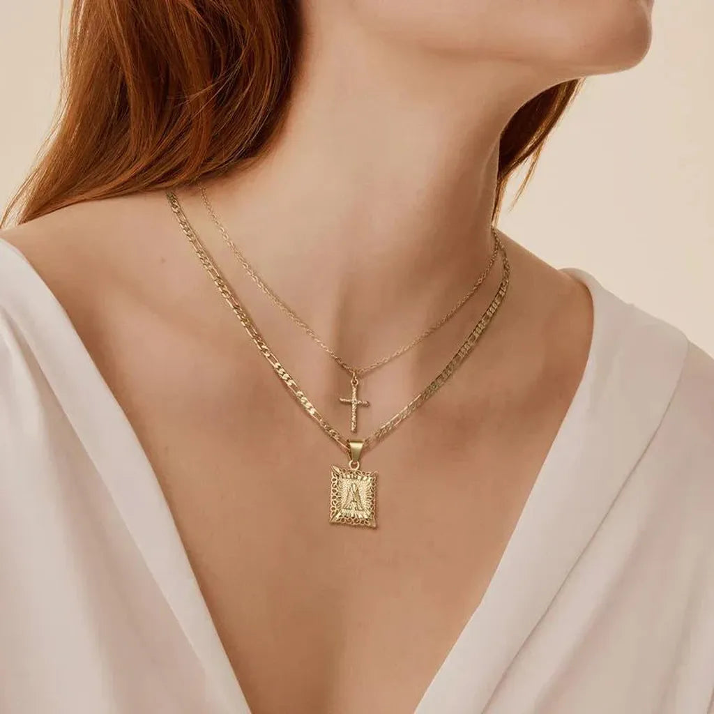 Collar doble con cruz e inicial · Dorado
