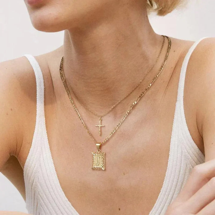 Collar doble con cruz e inicial · Dorado