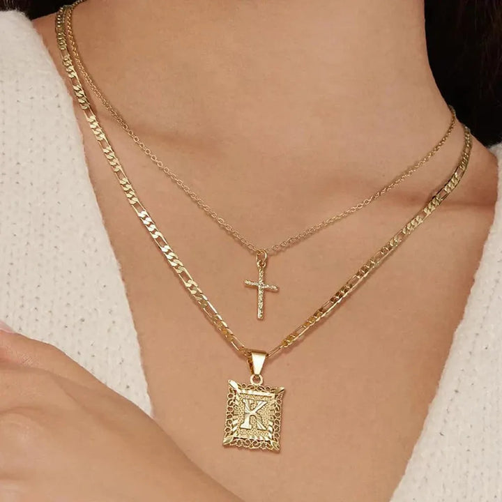 Collar doble con cruz e inicial · Dorado