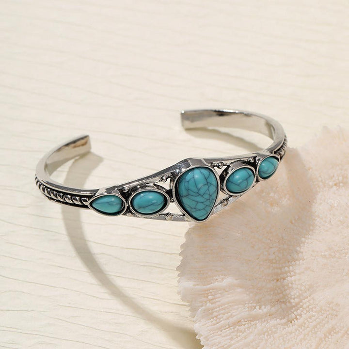 Brazalete abierto con gota turquesa · Plateado